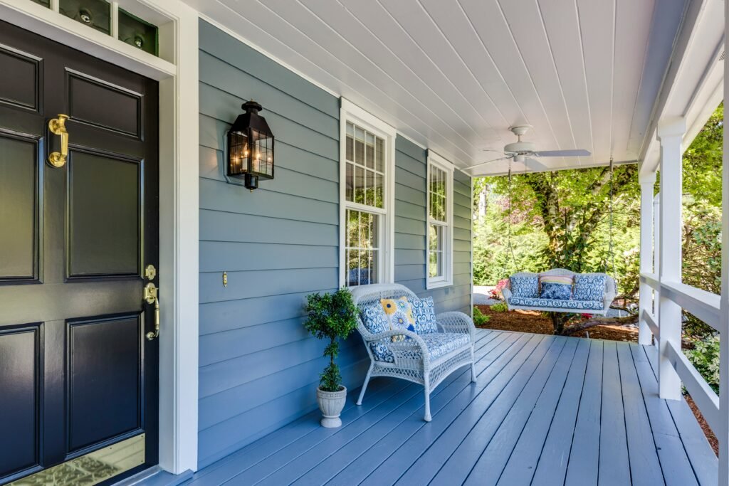 Pretty blue painted porch with swing and wicker chair